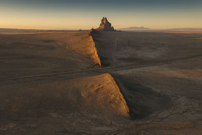 Scenic view of shiprock against sky during sunset