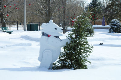 Polar bear flat sculpture accosting a tree