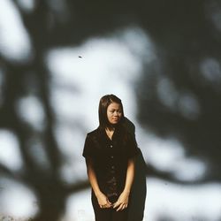 Young woman standing against wall