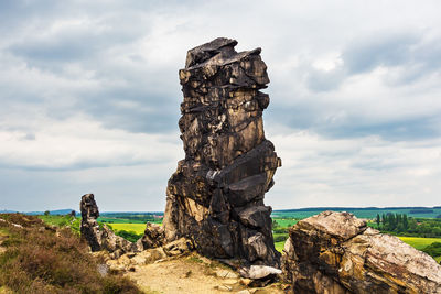 Stack of rock by sea against sky