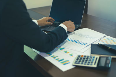 Midsection of businessman working on table