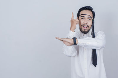 Smiling young man standing against white background