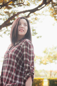 Portrait of teenage girl standing against plants