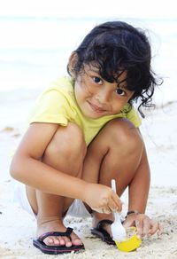 Cute boy sitting on beach