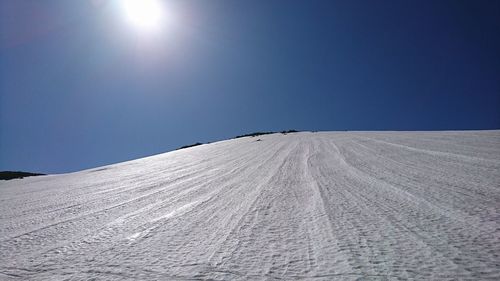 Scenic view of snowcapped landscape against clear blue sky