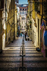 People walking on steps amidst buildings in city