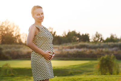 Portrait of smiling woman standing on field