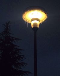 Low angle view of illuminated lamp against sky at night