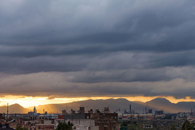 Buildings in city against sky during sunset