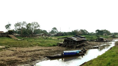 Boat in canal by building against clear sky