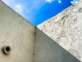 Low angle view of white wall against blue sky