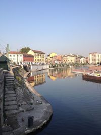 River in town against clear blue sky