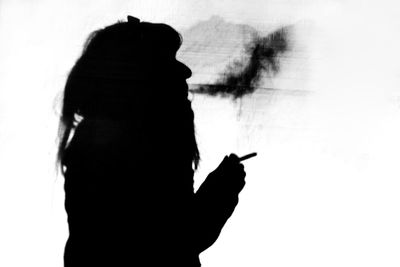 Silhouette woman hand against sky