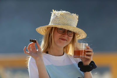 Portrait of woman holding mobile phone outdoors