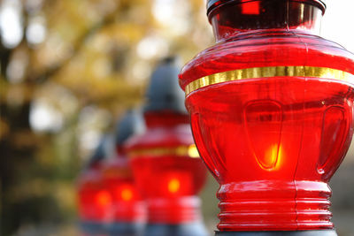 Closeup of red votive candles lit on tombstone