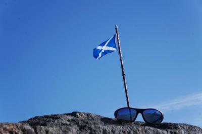 Low angle view of flag against blue sky