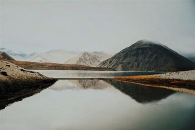 Idyllic view of rocky mountains and lake against sky