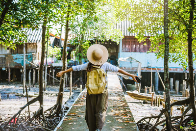 Rear view of person standing by canal