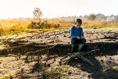 Boy standing on ground against sky