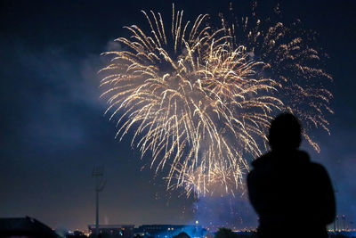 Silhouette of fireworks against sky at night