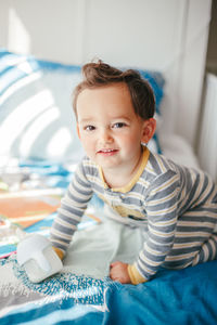  kid boy sitting on a bed drinking milk from a kids bottle. healthy eating drinking 