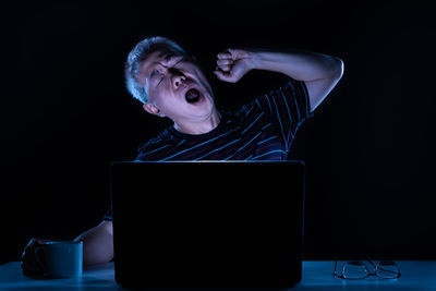 Man using laptop on black background