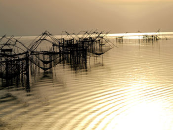 Pier over sea against sky during sunset