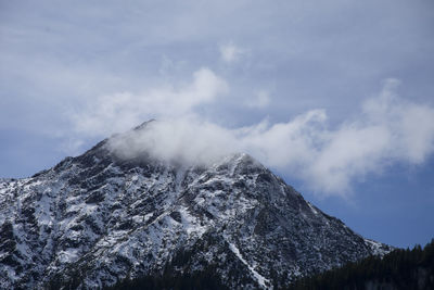 Low angle view of snowcapped mountain against sky