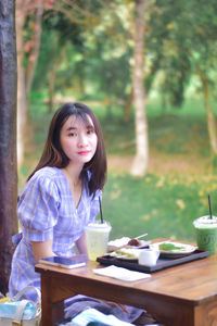 Young woman using mobile phone while sitting at outdoor cafe