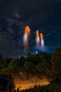 Low angle view of illuminated trees against sky at night