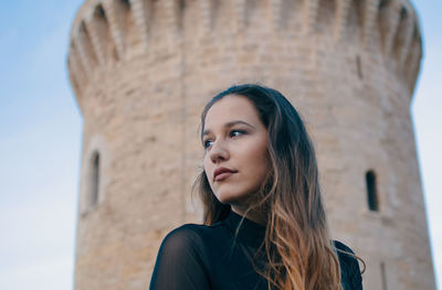 Low angle view of woman against historical building