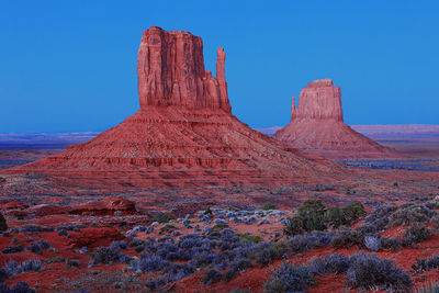 Rock formations on landscape against blue sky