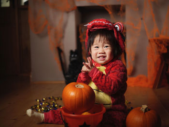 Portrait of cute baby girl in halloween costume sitting at home