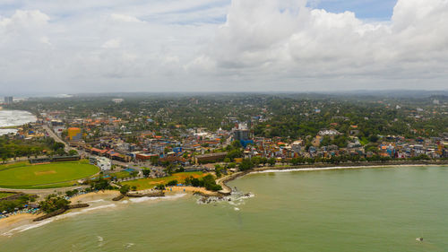 High angle view of townscape by sea against sky