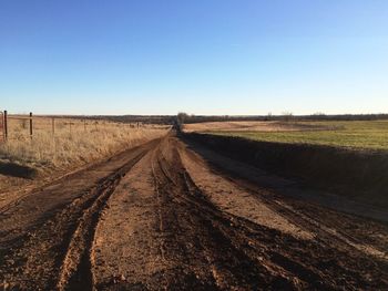 Dirt road against clear blue sky