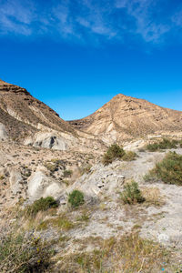 Scenic view of mountains against blue sky