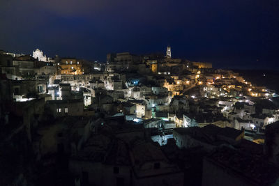 Illuminated town against sky at night