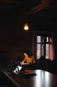 Woman sitting on table at home