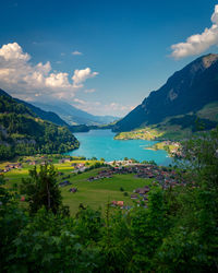 Scenic view of lake and mountains against sky in town