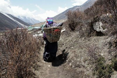 Woman standing on mountain against sky