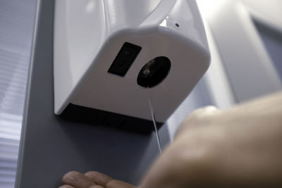 Close-up of hand sanitizing hands at home