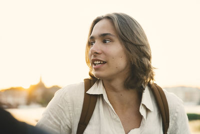 Portrait of smiling young woman against sky during sunset