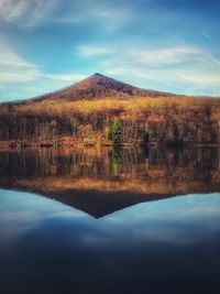 Scenic view of lake by mountain against sky