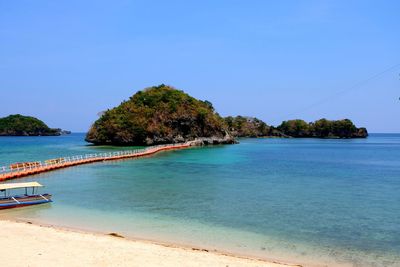 Scenic view of bay against clear blue sky