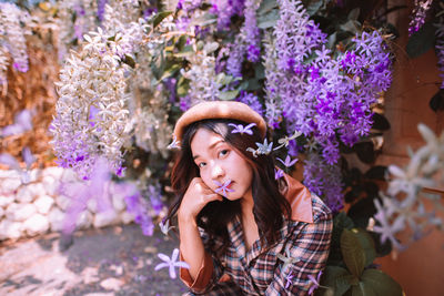 Portrait of young woman standing against trees