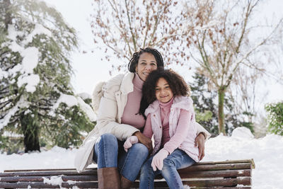 Portrait of a smiling woman sitting on snow