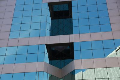 Low angle view of glass building against sky