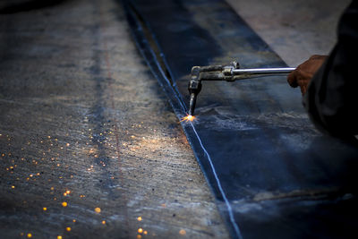 Cropped hand welding metal in workshop