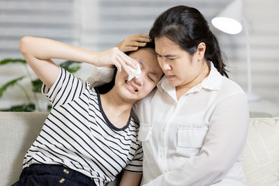 Mother consoling daughter at home