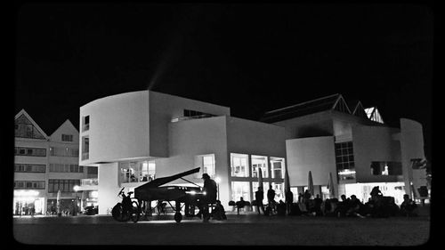 People on street against buildings at night